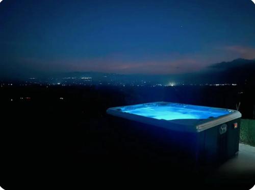 a blue tub sitting on the side of a building at night at Volcano Views Glampings & Crystal House in Monterrey