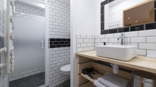 une salle de bain blanche avec un lavabo et des toilettes dans l'établissement L'Atelier Haute Couture, au Mans