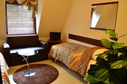 a bedroom with a bed and a chair and a plant at Camping Motel WOK in Warsaw