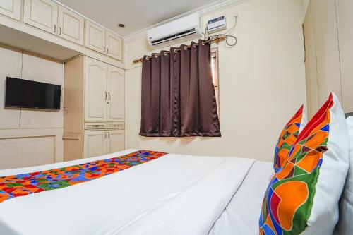 Habitación pequeña con cama y TV. en FabHotel Nest Inn Service Apartment en Chennai