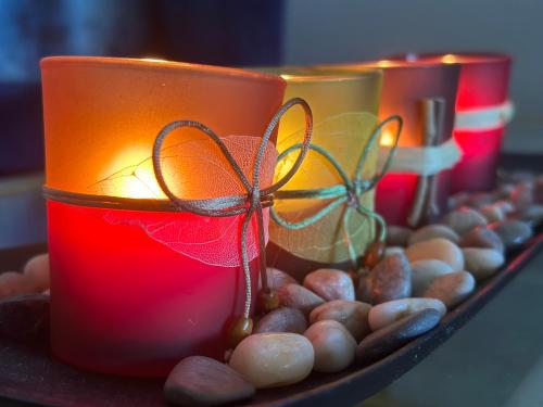 three candles sitting on a tray with stones and lights at Cozy room in Charlottesville in Earlysville