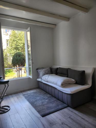 ein Sofa in einem Zimmer mit Fenster in der Unterkunft bel appartement in Villeneuve-Saint-Georges