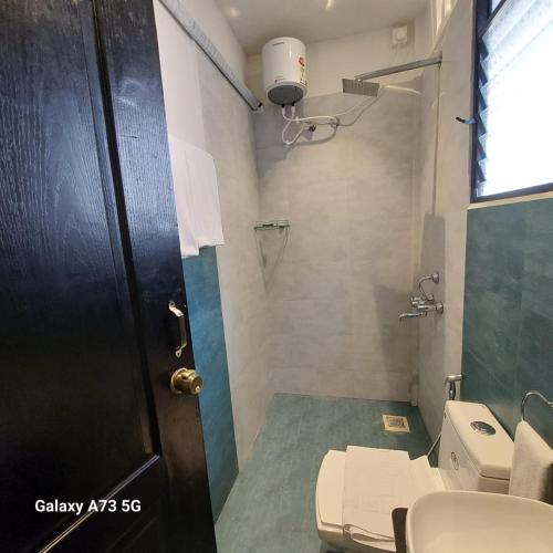 a bathroom with a toilet and a sink and a door at Arambol Sweet Lake Resort in Arambol