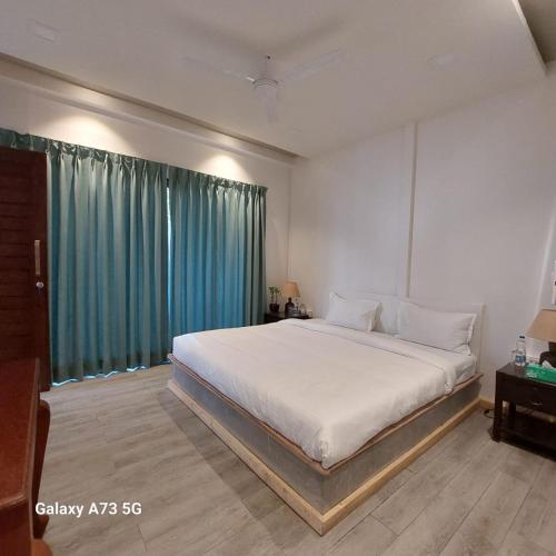 a bedroom with a large bed and a large window at Arambol Sweet Lake Resort in Arambol