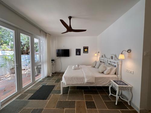 Schlafzimmer mit einem Bett und einem Deckenventilator in der Unterkunft Oceanic - Luxury Boutique Hotel in Palolem