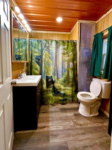托克的住宿－Roberts Lodge，浴室设有淋浴帘,森林里饲养着一只狗
