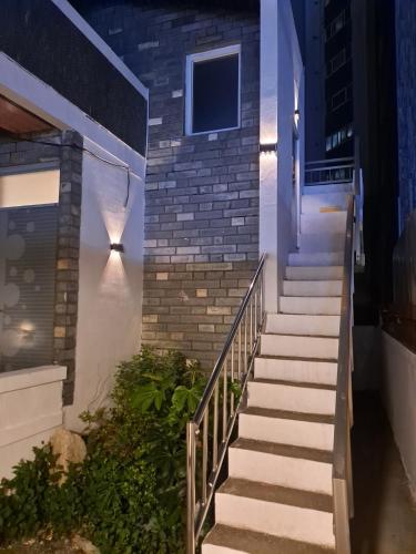 a set of stairs leading up to a building at night at Soban Stay in Busan