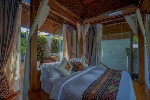 a bedroom with a bed in a room with windows at Gdas Bali Health and Wellness Resort - Adult Only in Ubud