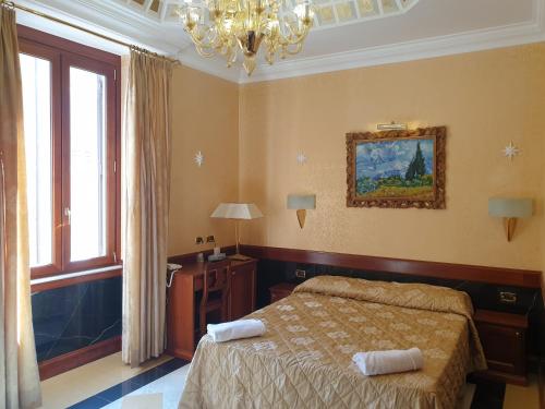 a bedroom with a bed and a window and a chandelier at Hotel Bolivar in Rome