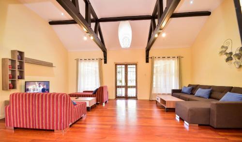 內羅畢的住宿－A PLACE OF TRANQUILITY, Muthaiga，带沙发和椅子的大客厅