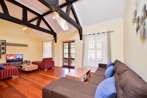 sala de estar con sofá y TV en A PLACE OF TRANQUILITY, Muthaiga en Nairobi