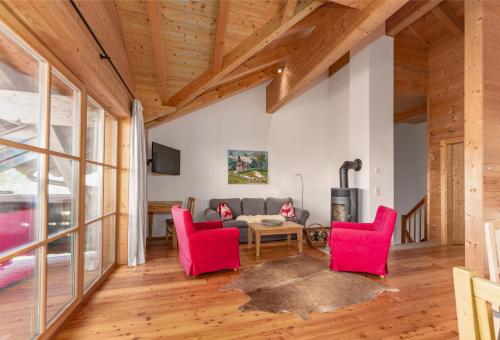 a living room with red chairs and a couch at Ski in/Ski out Chalets Tauernlodge by Schladming-Appartements in Schladming