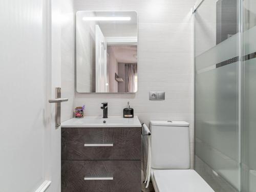 y baño con aseo, lavabo y espejo. en Incredible apartment in the heart of Granada, en Granada
