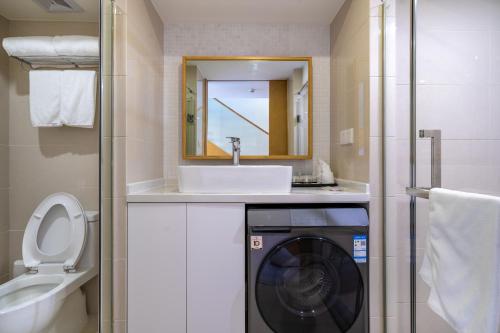 uma casa de banho com uma máquina de lavar roupa e um lavatório em Boutique houtel Shanghai Lujiazui em Xangai