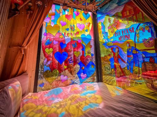 a bed in a room with hearts painted on the wall at Eco House Merisi in Merisi
