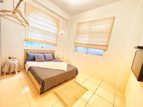 a bedroom with a bed and two windows at sea monkey diving homestay in Green Island