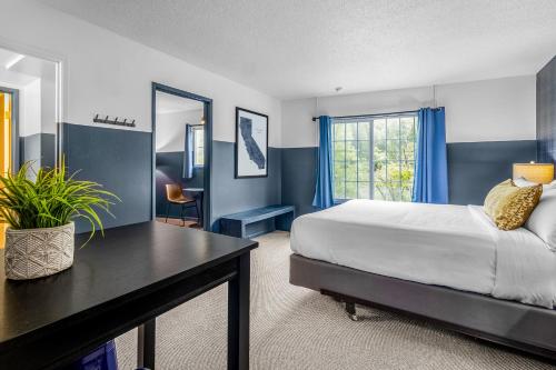 a bedroom with a bed and a desk and a window at The Angler Lodge in Dunsmuir