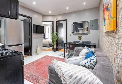 a living room with a couch and a kitchen at Spacious 4 Bedroom Apartment in New York