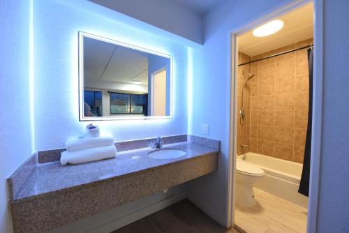 uma casa de banho com um lavatório, um WC e um espelho. em Boardwalk Suites Baton Rouge em Baton Rouge