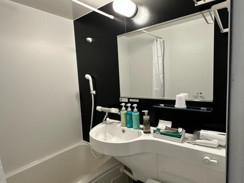 y baño con lavabo blanco y espejo. en Hotel Route Inn Fukushima Nishi Inter, en Fukushima