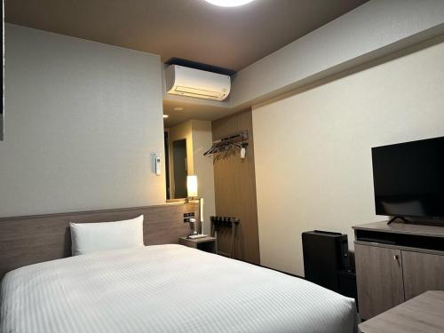 福島市にあるHotel Route Inn Fukushima Nishi Interのベッドルーム(ベッド1台、薄型テレビ付)