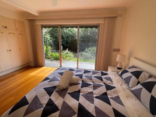 um quarto com uma cama e uma grande janela em Home in Brighton em Melbourne