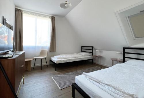a bedroom with a bed and a desk and a window at Nussbaum Panzió in Keszthely