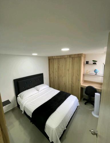 een slaapkamer met een groot bed en een bureau bij Roldan House in Sabaneta