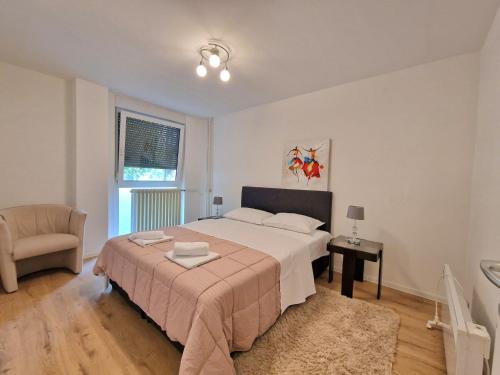 1 dormitorio con 1 cama blanca grande y 1 silla en Apartment YANNA comfort, free parking, en Osijek