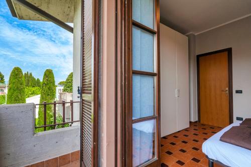 a room with a balcony with a bed and a window at Sara al Lago - con garage e WiFi in Sirmione
