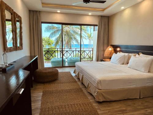 1 dormitorio con cama y vistas al océano en Canopus Retreat Thulusdhoo, en Thulusdhoo