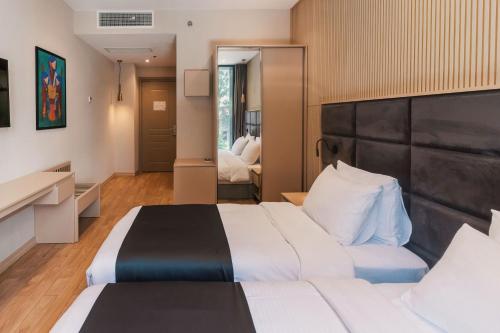 a hotel room with a large bed and a mirror at Hotel Monday by DNT Group in Tbilisi City