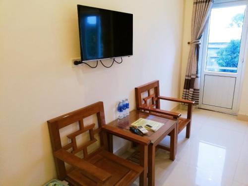 un soggiorno con 2 sedie, un tavolo e una TV di Thành Đạt Hotel a Cửa Lô
