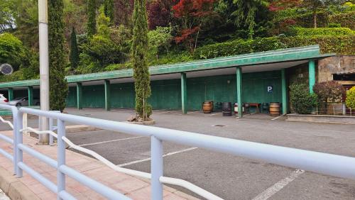 a green building with a tree in the parking lot at Pension Paloma - Oiartzun in Oiartzun