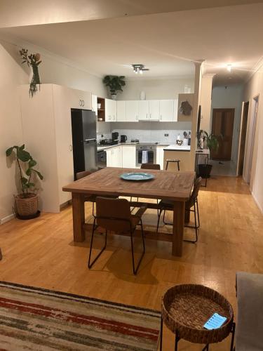 a living room with a wooden table and a kitchen at Riverside Boutique Apartment in Rockhampton