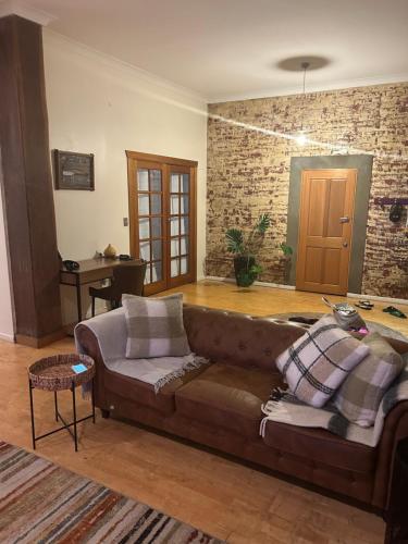 uma sala de estar com um sofá castanho e uma mesa em Riverside Boutique Apartment em Rockhampton