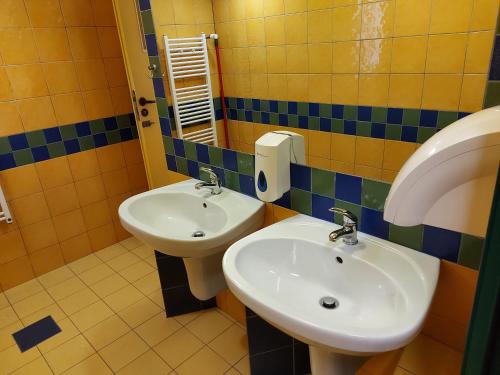a bathroom with two sinks and a mirror at Youth Hostel Podlasie in Białystok