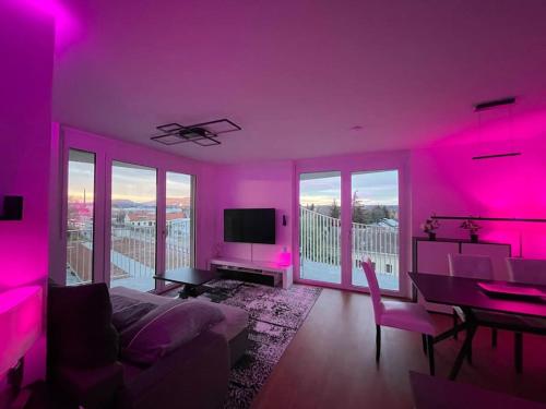 een woonkamer met roze verlichting op de muren bij Luxusapartment mit großer Terrasse, E-Parkplatz und Parkplatz in Graz
