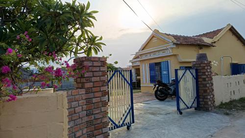 a blue gate in front of a house with a motorcycle at Ecohost Đông Hòa in Phú Hiệp