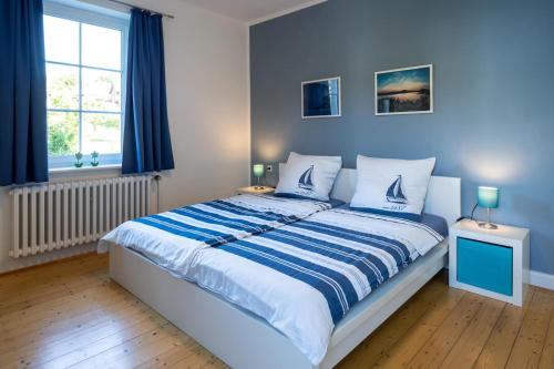 Schlafzimmer mit einem Bett mit blauen Wänden und einem Fenster in der Unterkunft Villa am Edersee in Hemfurth-Edersee
