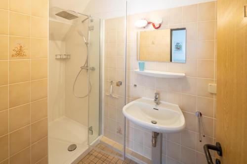 een badkamer met een wastafel en een douche bij Gemutliche 93m2Fewo mit 2 Schlafzimmern und seitlichem Seeblick vom Balkon in Scheid