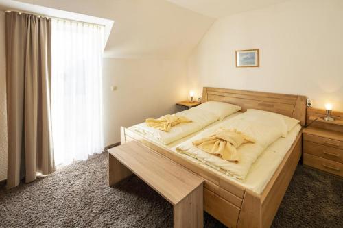 a bedroom with a large wooden bed with yellow sheets at Seeblick genießen in schöner FeWo am Edersee in Scheid