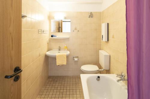 a bathroom with a tub and a toilet and a sink at Seeblick genießen in schöner FeWo am Edersee in Scheid