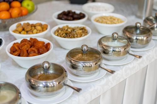 a buffet with pots and bowls of food on a table at Soluxe Hotel in Bishkek