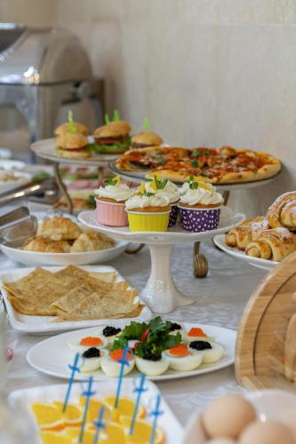 a table topped with plates of food and pastries at Soluxe Hotel in Bishkek