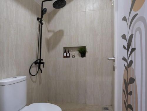 a bathroom with a shower with a toilet in it at Villa pak joni in Pasuruan