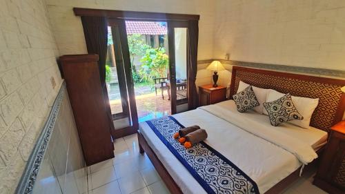 a bedroom with a bed and a door to a patio at Pala House in Ubud