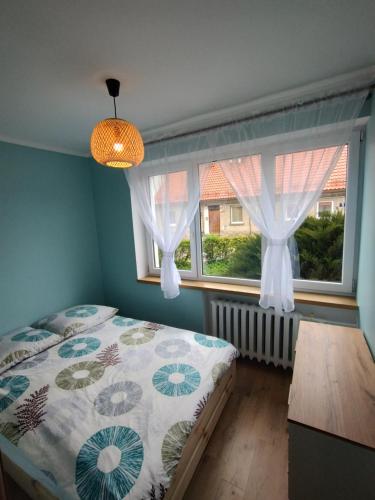 Schlafzimmer mit einem Bett und einem Fenster in der Unterkunft Apartament na Mazurach -Ryn in Ryn