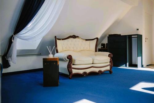 a bedroom with a white bed and a blue carpet at Stacja Kultura in Poniatowa