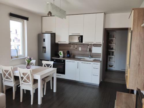 a kitchen with white cabinets and a table and chairs at Happy Apartment & Free Breakfast - Mladost in Sofia